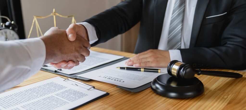 Lawyers shake hands with business people to seal a deal with partner lawyers. or a lawyer discussing